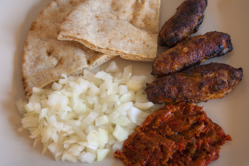 Ä†evapÄiÄ‡i served with ajvar, onions and pitta bread â€“ just the way I tried it in Mostar!