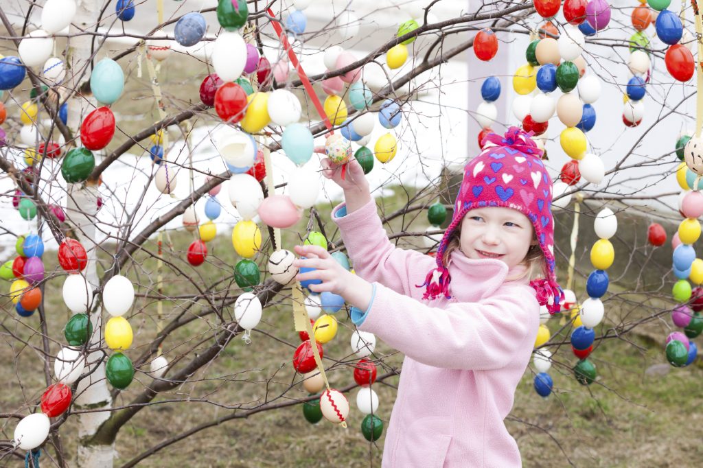 little girl standing by Easter tree