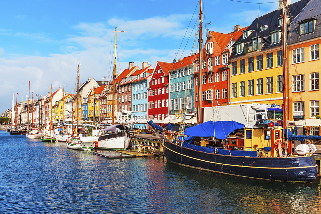 Scenic summer view of Nyhavn pier with color buildings, ships, yachts and other boats in the Old Town of Copenhagen, Denmark
